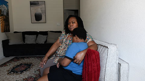 Ethan sitting with his mother in their house.