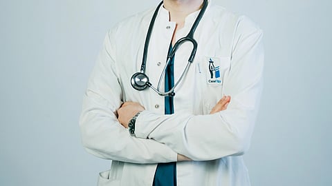 A doctor in white court with stethoscope around neck.