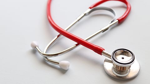 A red stethoscope kept on white background.