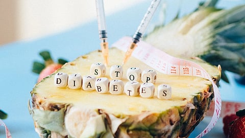Creative image depicting 'Stop Diabetes' message with pineapple and syringes, promoting health awareness