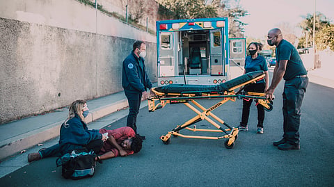 Paramedics carrying an injured person on a stretcher at the accident site