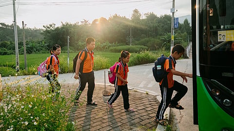 young children onboarding a green coloured school bus