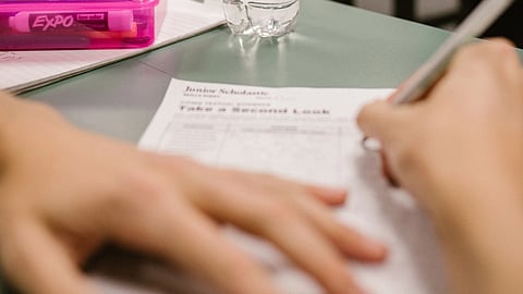 Someone writing a test using pen.
