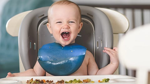 Happy child eating solid food
