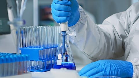 Close up of researcher testing liquid sample using micropipette