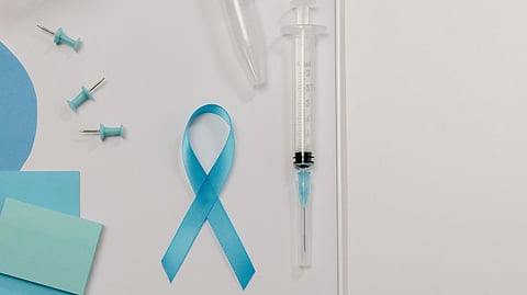 Blue ribbon with a syringe next to some push pins