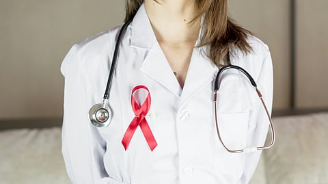 Doctor wearing a stethoscope and a cancer ribbon