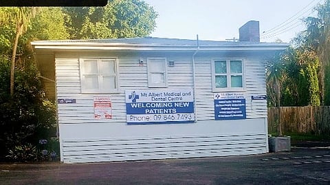 Mt Albert Hospital with banners on white building.