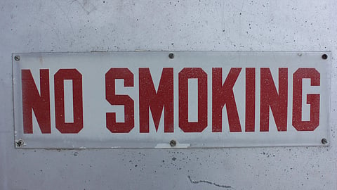 Close-up of a bold 'No Smoking' sign on a textured wall