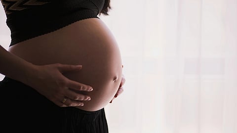 Pregnant woman holding her belly