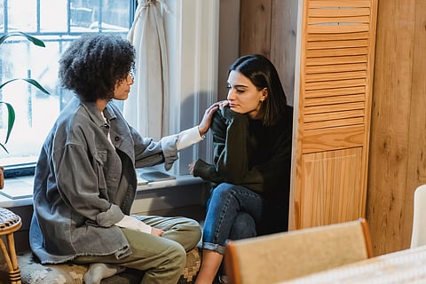 Two friends sharing a comforting moment at home, showcasing empathy and support