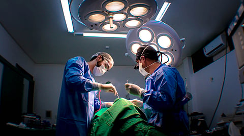 Two surgeons performing surgery in a well-equipped operating room