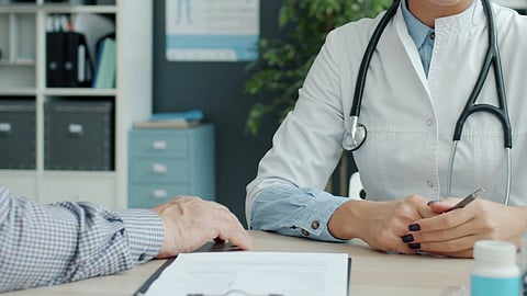 A doctor sitting with a patient.