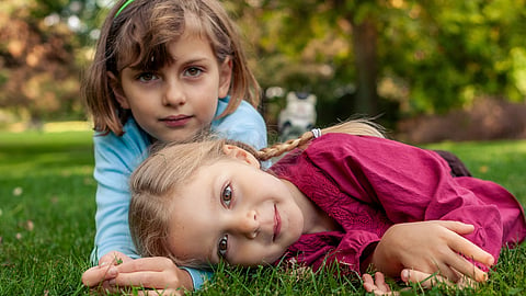 sisters lying on the grass