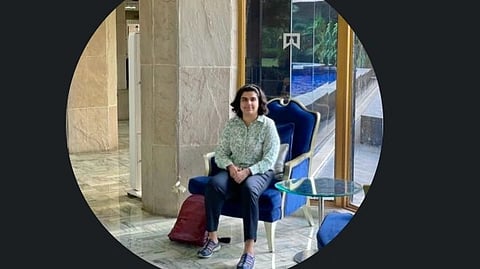 Dr. Komal sitting on a blue chair.