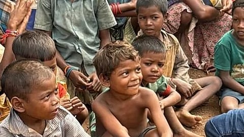 A bunch of kids sitting together on land.