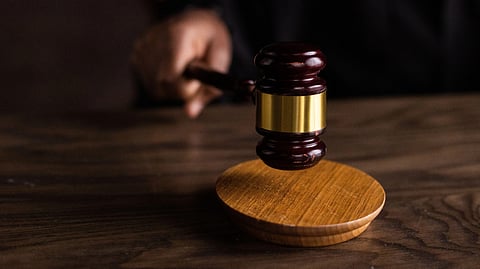 A court gavel on a brown table.
