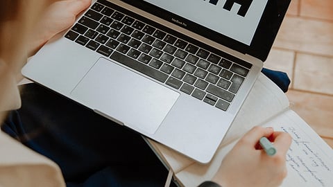 individual taking notes about mental health from a screen