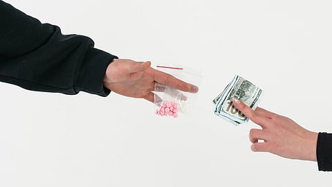 person trading money for drugs