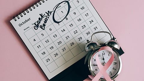 close up shot of a pink ribbon beside a calendar