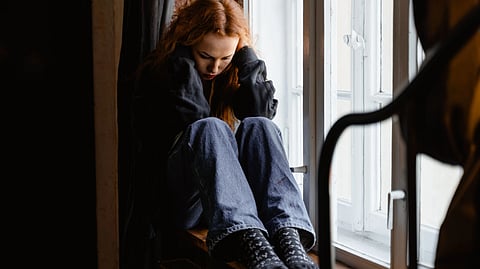 distressed child sitting by the window