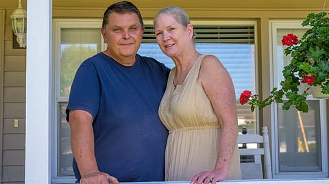 Amye and Charlie Joseph standing on their house porch