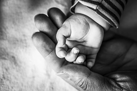 toddler and parent hand in black and white 