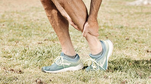 Person holding his paining leg