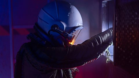 Astronaut in a futuristic space suit exploring a spacecraft with vivid lighting