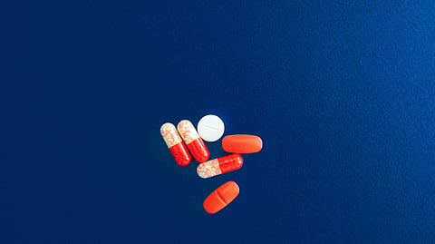 Capsules and tablets on blue background.