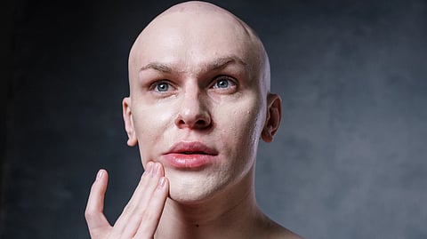 man touching his face