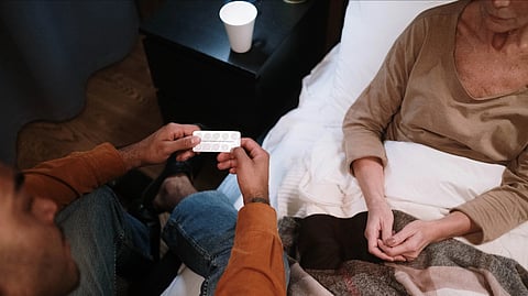 Caregiver giving medicines to patient