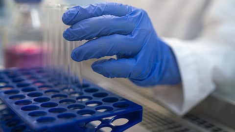 A scientist holding a test tube in a lab.