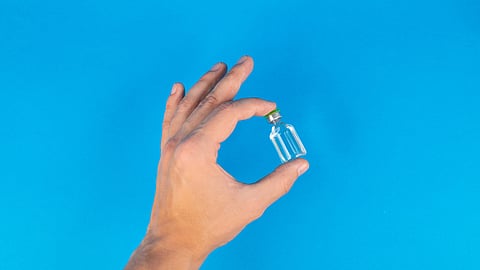 hand holding a small glass bottle