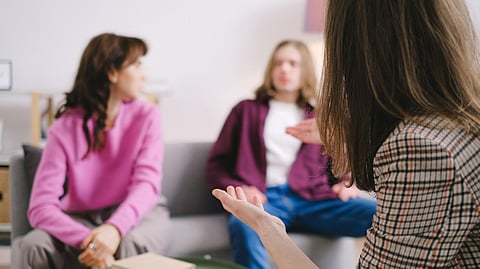 2 clients with therapist in therapy.