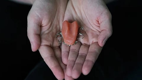 A hand holding a prosthetic tongue