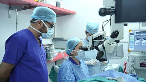 Surgeons performing eye surgery in a New Delhi hospital operating room