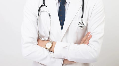 Doctor standing with his hands folded