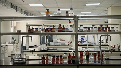 chemicals in lab with different bottles on shelves.