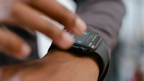 A detailed image showing a person interacting with a smartwatch, highlighting fitness tracking capabilities