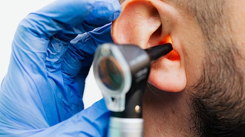 Doctor checking ear with a machine