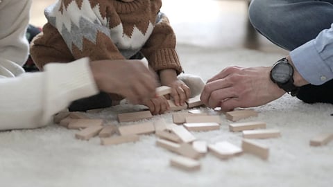 man and woman playing with their child