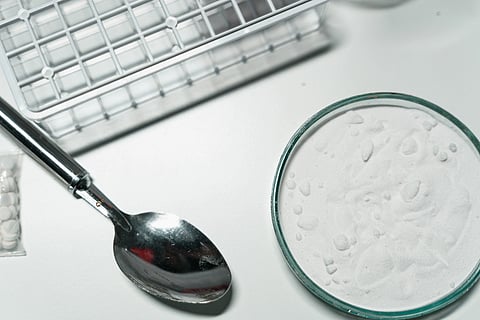shot of silver soon and illegal drugs on white surface