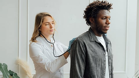 Doctor conducting check-up on patient with stethoscope indoors