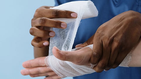 person getting his hand bandaged