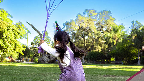 child enjoying outdoor play with balloons