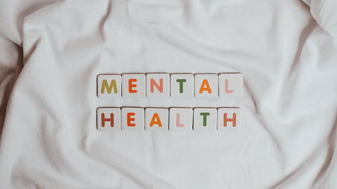Mental Health written on white cloth with different colored letter boxes.