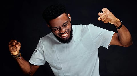 A man in a white t - shirt is holding his fist up
