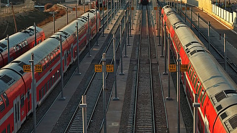 Passenger trains aligned at a railway station captured from above, showcasing transportation infrastructure