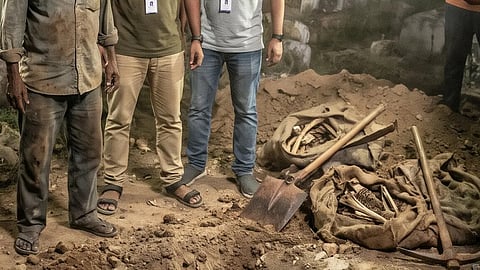 three men standing next to bags filled with bones